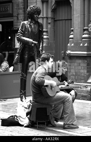 Musicista di strada accanto a Phil Lynott statua, Dublino, Irlanda Foto Stock