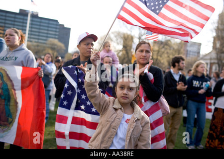 Una piccola ragazza rinuncia a un flag di noi durante un Rally di immigrazione Foto Stock