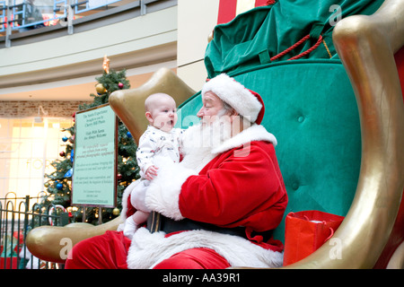 Babbo Natale in un centro commerciale con eccitato baby Foto Stock