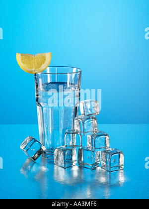 Bicchiere di acqua minerale con cubetti di ghiaccio e limone Foto Stock