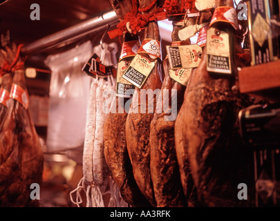 Barcellona, Catalunya, Spagna. Prosciutto Iberico e salami appesi in stallo Mercat de la Boqueria (il mercato) Foto Stock