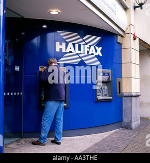 Vista posteriore di un uomo che utilizza la cassa ATM fuori Halifax Building Society su una strada alta in Cardiff Galles Gran Bretagna KATHY DEWITT Foto Stock
