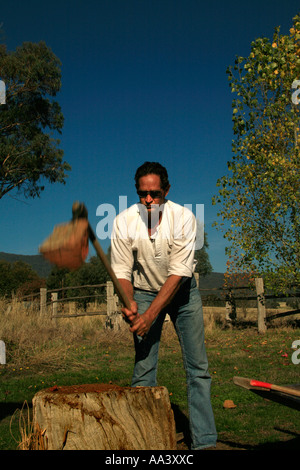 Un uomo trita fiume gomma rossa di legna da ardere in Australia. Foto Stock