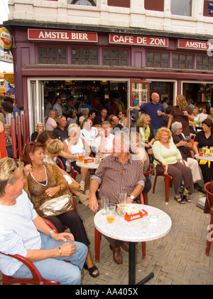 La folla presso il cafe bar in piazza Nieuwmarkt guarda outdoor entertainment Amsterdam Paesi Bassi Foto Stock