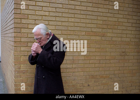 L'uomo accendere una sigaretta London REGNO UNITO Foto Stock