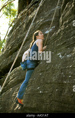 Una femmina di rocciatore utilizza Chalk custodia come lei le scale di una scogliera di arenaria a Barrenjoey vicino a Palm Beach Pittwater Sydney Foto Stock