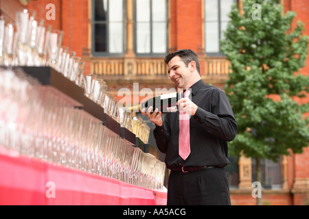 Uomo che serve champagne a parte Foto Stock