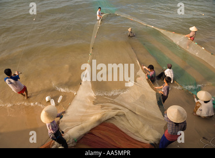 Mui Ne, Vietnam. Gli uomini e le donne di pesca salpamento nemui net Foto Stock