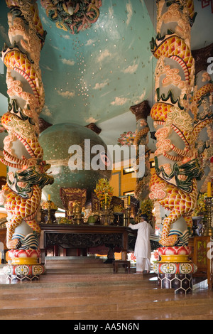 Tay Ninh, Vietnam. Gran Tempio Cao Dai, un sacerdote assiste ad occhio divino altare nel santuario principale Foto Stock