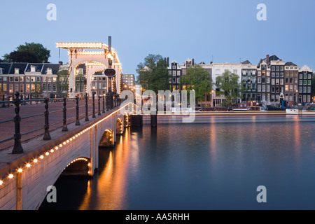 Amsterdam, Paesi Bassi. Magere Brug noto anche come ponte di Skinny accesa al crepuscolo Foto Stock