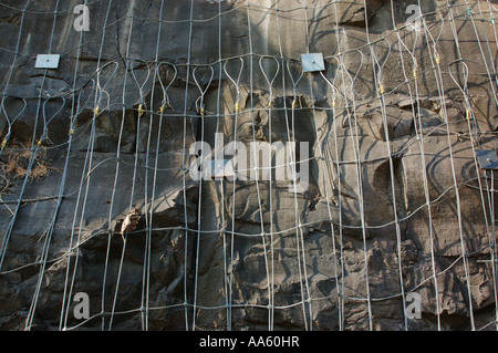 Rete di filo di acciaio inchiodata in rocce per tenere frane sciolte rocce del taglio ripido di collina per passare Konkan Railway vicino Mumbai india asia Foto Stock