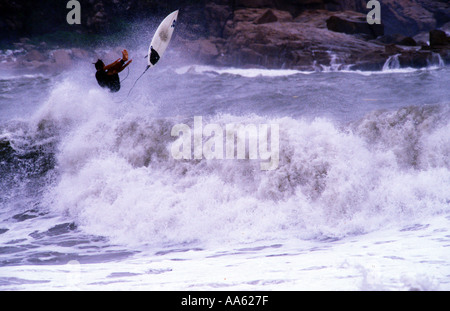 Un surfista ottiene alcuni aria come lui si pulisce fuori su una grande onda disordinato a Shek-o spiaggia di Hong Kong Foto Stock