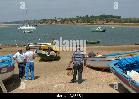 Spiaggiata e affondata barche da pesca in acqua a Alvor Città Algarve Portogallo Foto Stock