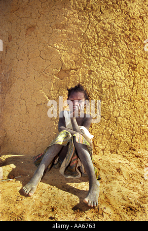 Una ragazza della Mauritania si siede accanto al suo rifugio realizzato da fango nel villaggio di Bounessa nella regione Affole della Mauritania Bounessa è Foto Stock