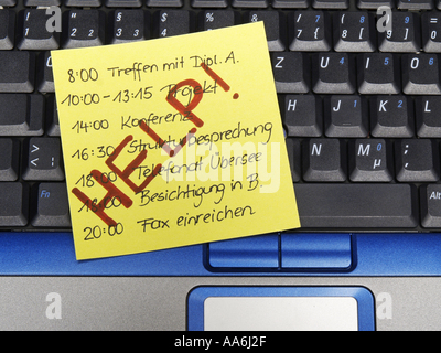 Nota memo su notebook per il programma completo con segno Hilfe aiuto Foto Stock