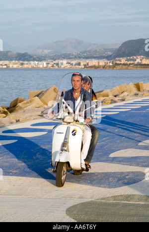 Coppia giovane in Vespa accanto al mare, Palermo Sicilia Italia Foto Stock