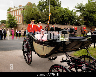 Foto d'archivio della Regina Elisabetta II con indosso un abito rosa pallido che arriva al Royal Ascot tenuto all'ippodromo di York in una carrozza trainata da cavalli. Foto Stock