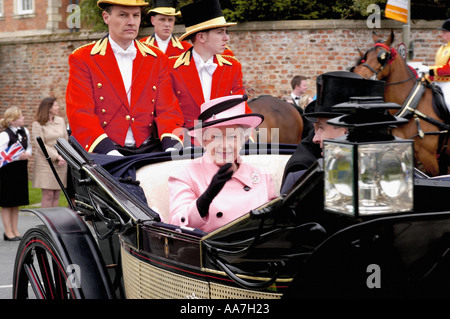 Foto d'archivio della Regina Elisabetta II con indosso un abito rosa pallido che arriva al Royal Ascot tenuto all'ippodromo di York in una carrozza trainata da cavalli. Foto Stock