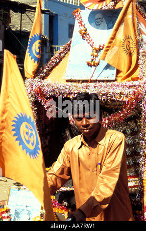 Il devoto indiano di Saint e Fakir Sai Baba di Shirdi che spinge il trolley con i simboli Om, Mumbai, India del Sud Foto Stock