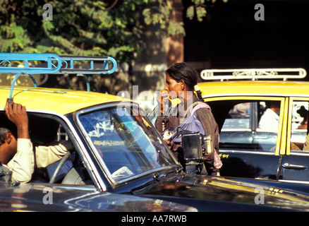 Donna indiana che mendicava al finestrino giallo/nero del taxi in ingorgo, Mumbai, India del Sud 2004 Foto Stock