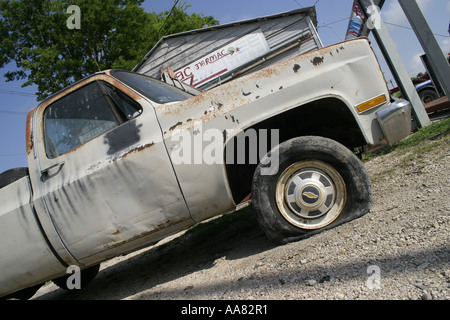 Vecchio carrello con un pneumatico sgonfio Foto Stock