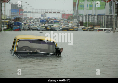 Taxi semi sommersa in alluvioni strada allagata a causa di piogge monsoniche a Bombay Mumbai India Asia Foto Stock