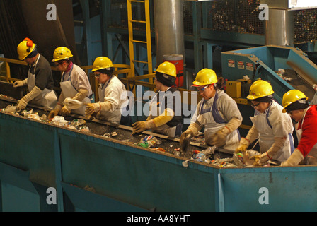 I lavoratori sono ordinamento tramite materiale misto e separare i metalli plastiche e carte dal cestino e vetro Foto Stock