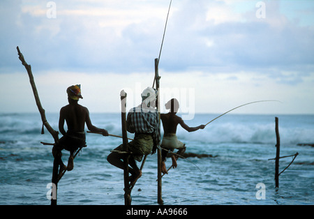 Stilt pescatori permanente sulla loro poli tra Unawatuna e Weligama Sri Lanka Foto Stock