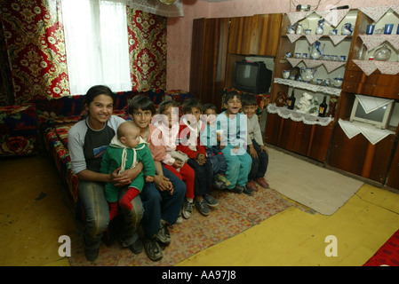 ROMA bambini zingari seduti su un letto in una casa su un sito nei pressi di Kosice in Slovacchia Foto Stock