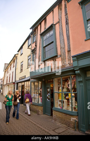 Due donne a piedi a mangiare il gelato in strada per lo shopping Hay on Wye Wales UK Foto Stock