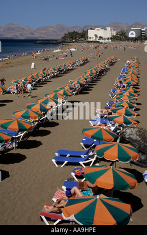 I vacanzieri su lettini su Playa Blanca spiaggia di Puerto del Carmen Lanzarote Spagna Foto Stock