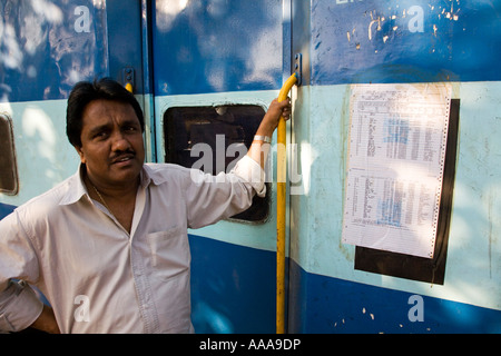 Maharastra a Kerala sulla ferrovia Konkan un uomo in piedi al di fuori del treno accanto a un pasengerlist Foto Stock