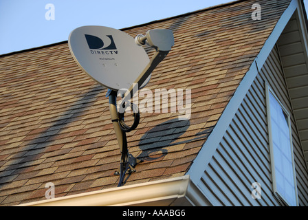 Una parabola satellitare sul tetto di una casa fornisce proprietario di casa con scelte per la televisione radio e connessione a internet ad alta velocità Foto Stock