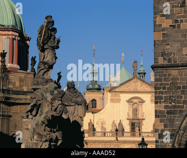 Sculture ornate in pietra su Karlûv Most (Ponte Carlo), con cupole della chiesa oltre, Praga, Repubblica Ceca. Foto Stock