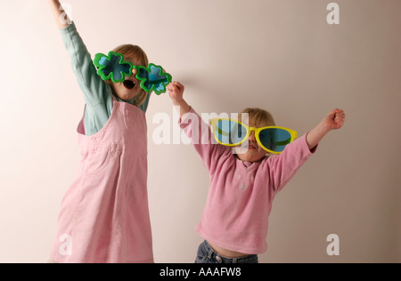 Sorelle a giocare in grandi occhiali da sole i bambini divertendosi attraverso il gioco Foto Stock