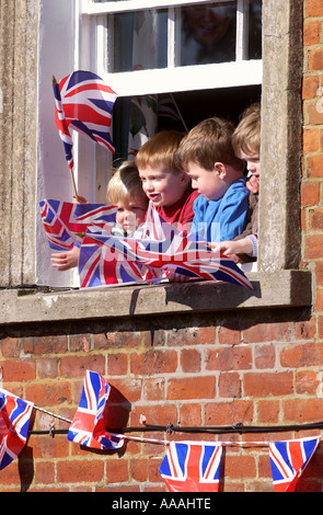 Bambini sventolare la bandiera europea da una finestra IN PEWSEY WILTSHIRE AL WELCOME HOME INVERNO MEDAGLIA D'ARGENTO SHELLEY RUDMAN REGNO UNITO Foto Stock