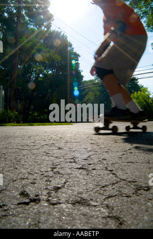 Ragazzo Skateboard Equitazione avendo divertimento al sole, STATI UNITI D'AMERICA Foto Stock