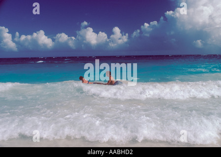 Bermuda giovane coppia adulta che gioca in onde infranti anni '1980 HOMER SYKES Foto Stock