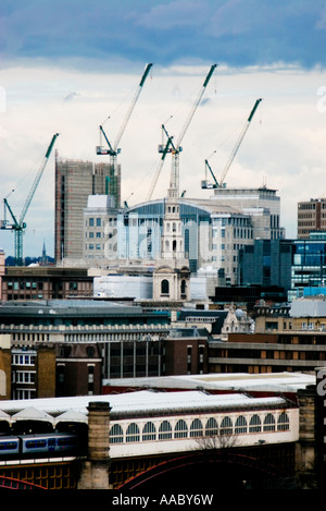 Costruzione inutilizzati gru in London line fino in parallelo oltre lo skyline della città al buio su un nuvoloso giorno Foto Stock