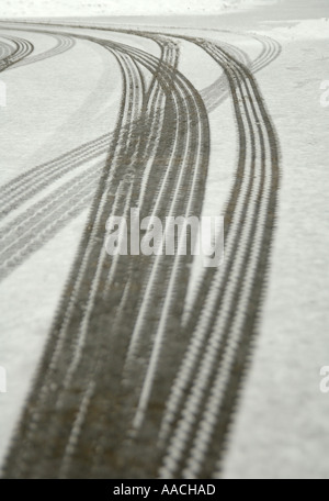 Slidare i segni dei pneumatici in un leggero strato di neve a Tunbridge Wells. Scatto con una profondità di campo bassa, rendendo il primo piano fuori fuoco. Foto Stock