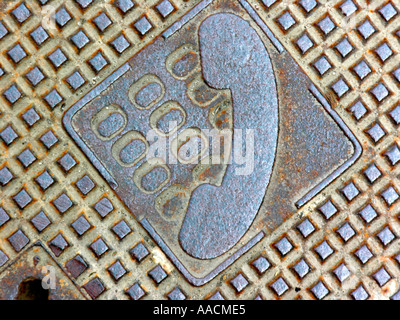 Simbolo per telefono su un ferro da stiro chiusino di metropolitana di installazioni telefoniche Foto Stock