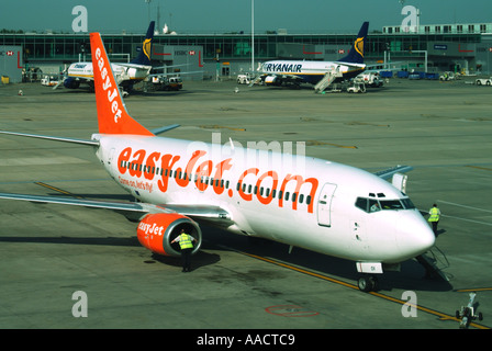 Aeroporto di Londra Stansted primo piano aereo EasyJet e 2 distanti due aerei Ryanair su banchi di cemento a terra a Essex Inghilterra Regno Unito Foto Stock