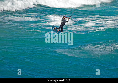 Solitario kite surfer e piacevoli schemi di acqua, a Praia da Bordeira, Algarve, Portogallo. Foto Stock