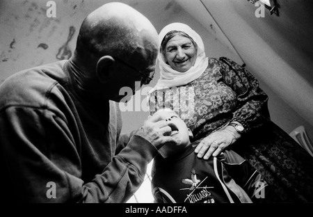 Dr. Yigal Shochat dal PHR Medici per i diritti umani che controllano un ragazzo palestinese durante una visita di clinica mobile nella Cisgiordania Israele Foto Stock