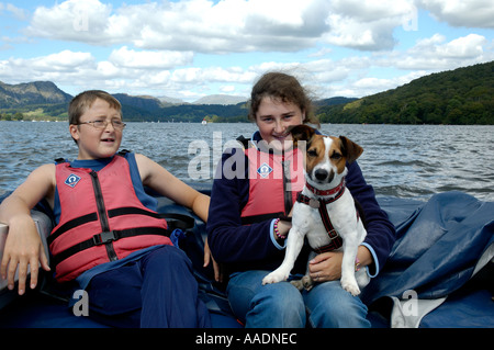 Fratello e Sorella holding Jack Russell cane sulla barca elettrica sul Coniston Water Lake District Cumbria Regno Unito Foto Stock