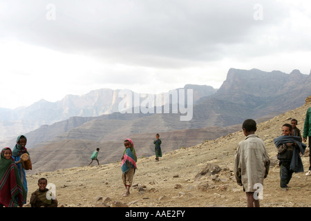 Trek Guide gioca palla con bambini locali durante il trekking in Simien Mountains National Park, Etiopia, Africa Foto Stock