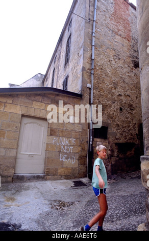 Ragazzo passeggiate passato graffitti nella città francese Foto Stock