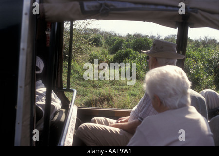 Anziani turisti guardando una leonessa dalla finestra di una facciata aperta LANDROVER Masai Mara Kenya Foto Stock