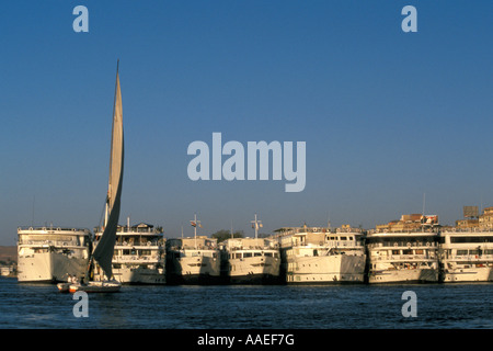 Lone Felucca e lineup di Crociera sul Nilo navi a Aswan, Egitto Foto Stock