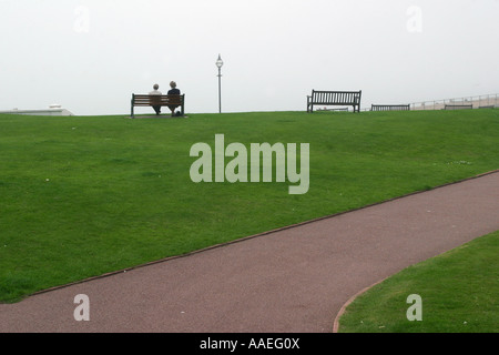 Due pensionati seduti su una panchina che guarda al mare in un mare di nebbia sul fronte mare, a Bexhill-on-Sea, Sussex, Regno Unito. Maggio 2007. Foto Stock